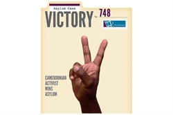 [ai] An image of a magazine cover featuring a hand making a peace sign. The title reads "VICTORY" in large letters, with the subtitle "Cameroonian Activist Wins Asylum" below. The cover is decorated with the text "Asylum Case No. 748" and includes a logo in the top right corner.