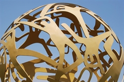[ai] A spherical sculpture made of intertwined metallic shapes against a clear blue sky. The design features cut-out figures creating a dynamic and open structure.